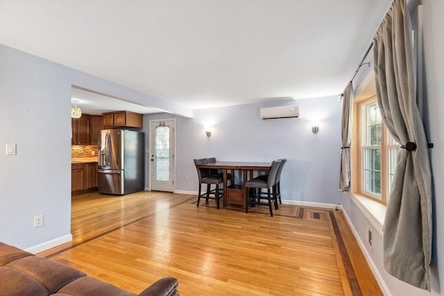 living room with light hardwood / wood-style flooring and an AC wall unit