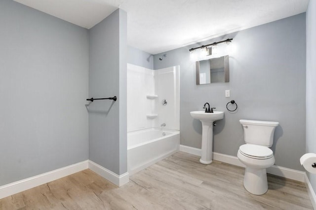 bathroom with shower / bath combination, hardwood / wood-style flooring, and toilet