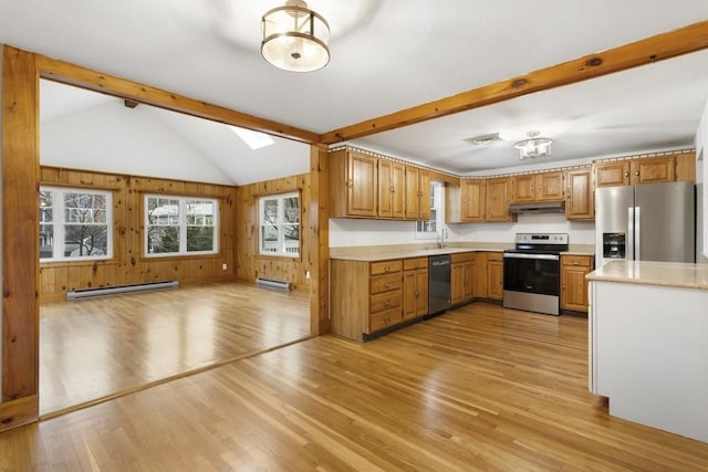 kitchen with stainless steel appliances, lofted ceiling with skylight, a baseboard radiator, and light hardwood / wood-style flooring