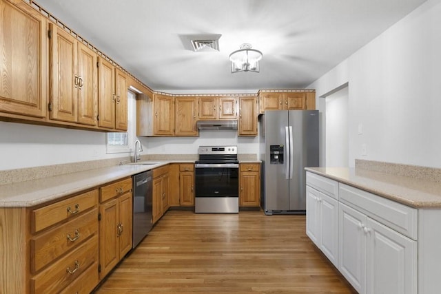 kitchen with light hardwood / wood-style flooring, stainless steel appliances, and sink