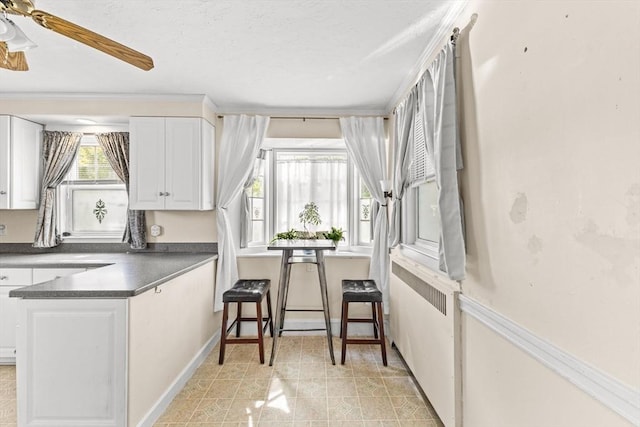 51 Gifford St, Brockton, MA 02301 - kitchen featuring white cabinets, dark countertops, a ceiling fan, light flooring, and baseboards