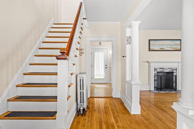 51 Gifford St, Brockton, MA 02301 - stairs with radiator heating unit, decorative columns, hardwood / wood-style floors, a fireplace with flush hearth, and crown molding