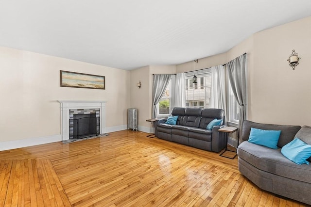 51 Gifford St, Brockton, MA 02301 - living area featuring light wood-style flooring, radiator heating unit, a fireplace with flush hearth, and baseboards