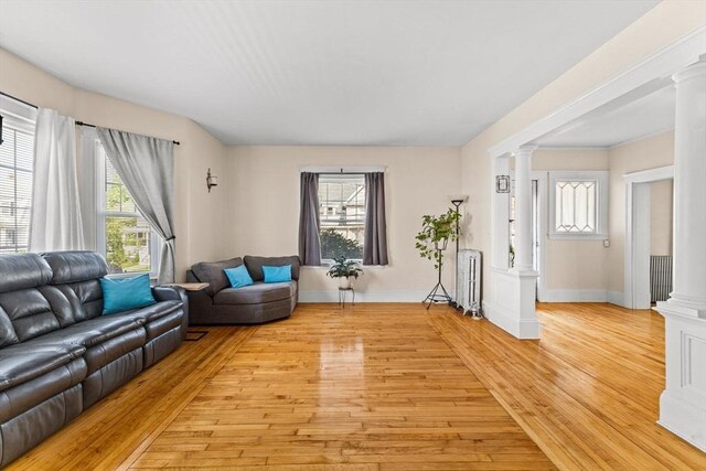 51 Gifford St, Brockton, MA 02301 - living area featuring ornate columns, radiator, light wood-style floors, and baseboards