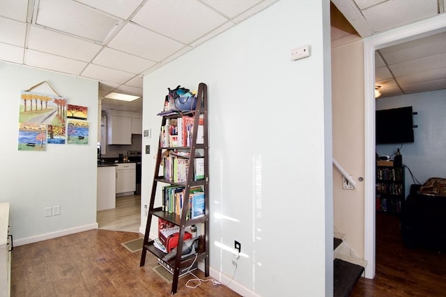 hall featuring a paneled ceiling and hardwood / wood-style flooring