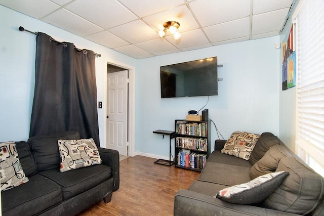 living room featuring hardwood / wood-style floors and a drop ceiling