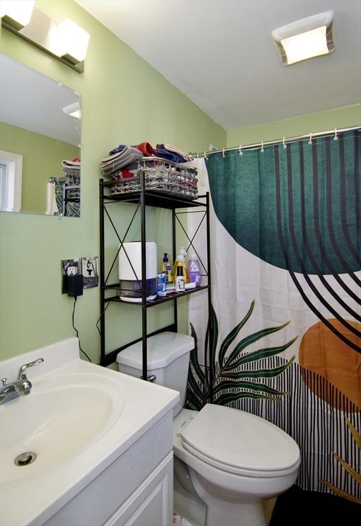 bathroom with a shower with curtain, vanity, and toilet