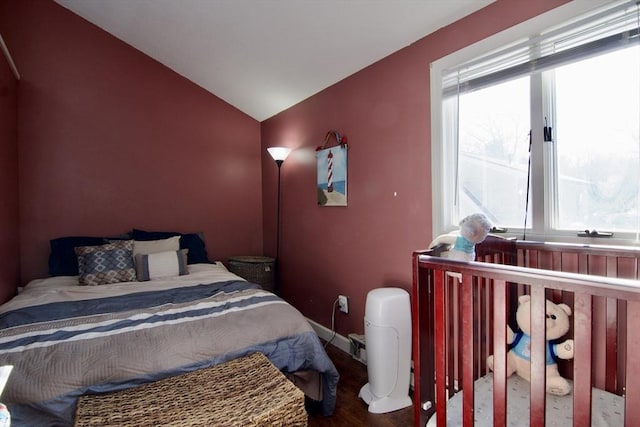 bedroom with hardwood / wood-style flooring and lofted ceiling