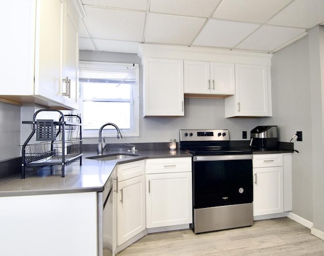 kitchen with a drop ceiling, sink, white cabinetry, and stainless steel appliances