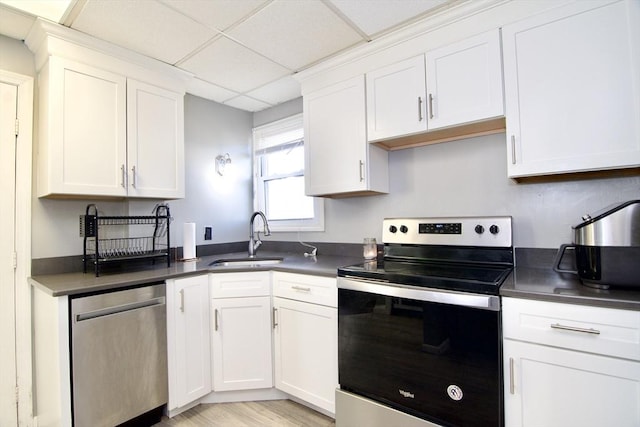 kitchen featuring white cabinets, stainless steel appliances, a drop ceiling, and sink