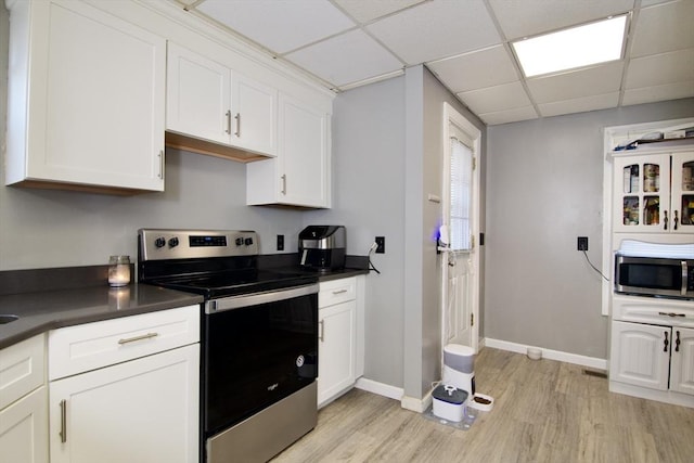 kitchen with a paneled ceiling, light hardwood / wood-style flooring, white cabinets, and stainless steel appliances