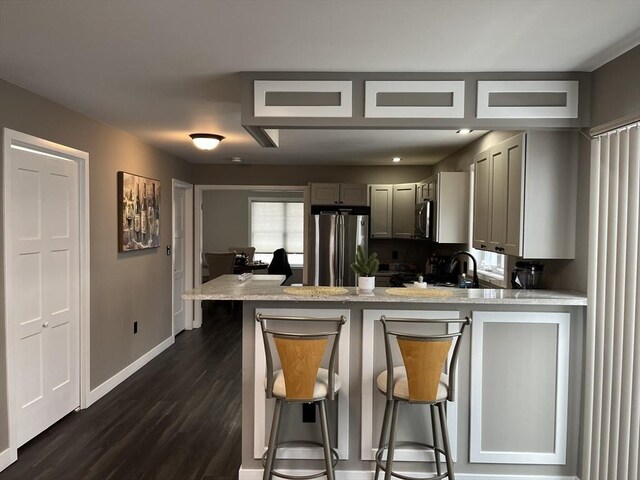 445 Cambridge St Unit 445, Worcester, MA 01610 - kitchen featuring appliances with stainless steel finishes, gray cabinetry, a peninsula, baseboards, and dark wood-type flooring