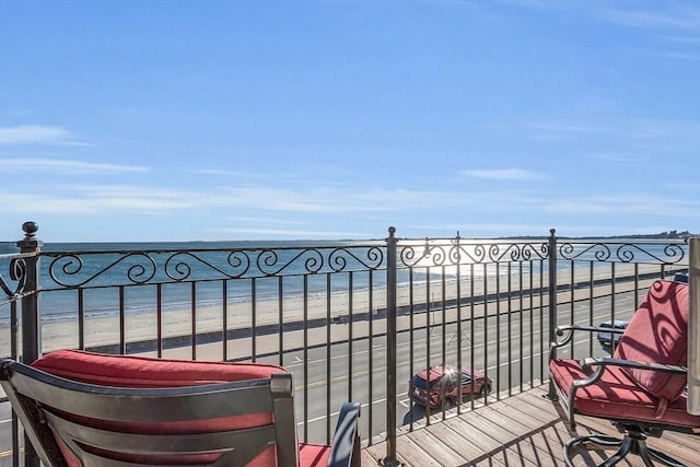 balcony featuring a water view and a view of the beach