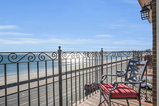 balcony with a water view and a view of the beach