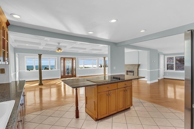 kitchen featuring a kitchen breakfast bar, a center island, plenty of natural light, and beam ceiling