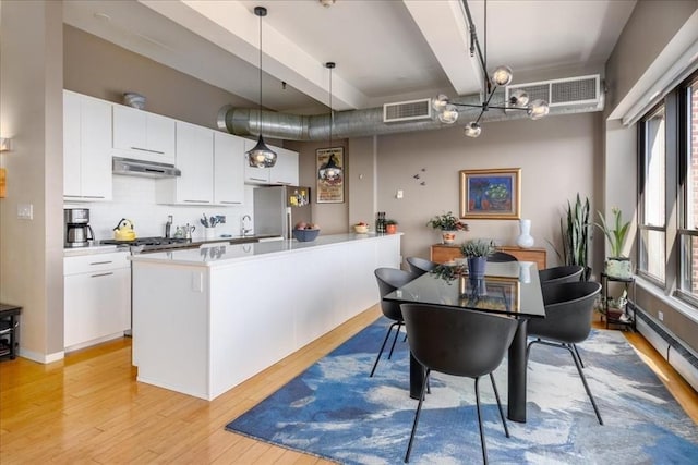 156 Porter St Unit 434, Boston, MA 02128 - kitchen with freestanding refrigerator, light wood-style floors, white cabinets, extractor fan, and tasteful backsplash