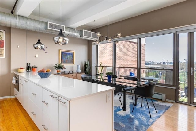 156 Porter St Unit 434, Boston, MA 02128 - kitchen with light wood-style floors, white cabinetry, a peninsula, and decorative light fixtures