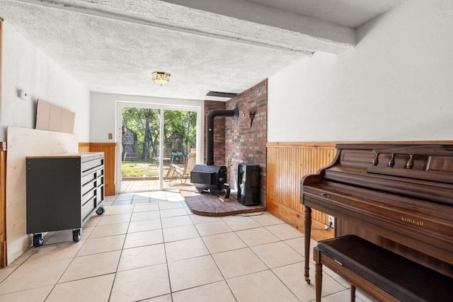 24 Springwell Rd, Billerica, MA 01821 - living room with wainscoting, a wood stove, light tile patterned floors, wooden walls, and a textured ceiling
