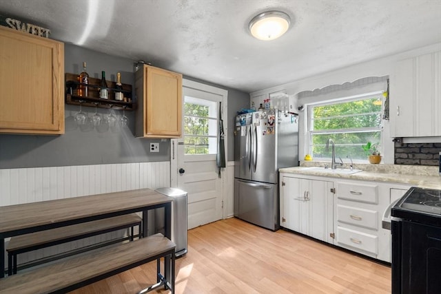 24 Springwell Rd, Billerica, MA 01821 - kitchen with freestanding refrigerator, light countertops, black range oven, light wood finished floors, and light brown cabinetry