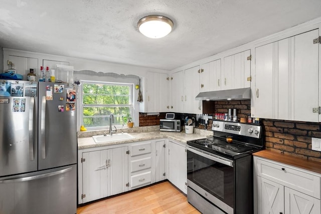 24 Springwell Rd, Billerica, MA 01821 - kitchen featuring stainless steel appliances, under cabinet range hood, white cabinets, light wood finished floors, and a textured ceiling