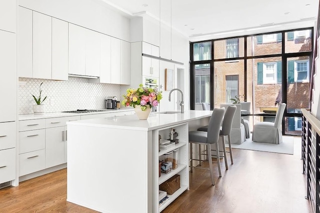 1-17 Edgerly Pl Unit 13, Boston, MA 02116 - kitchen featuring modern cabinets, a kitchen breakfast bar, light wood-style flooring, plenty of natural light, and expansive windows