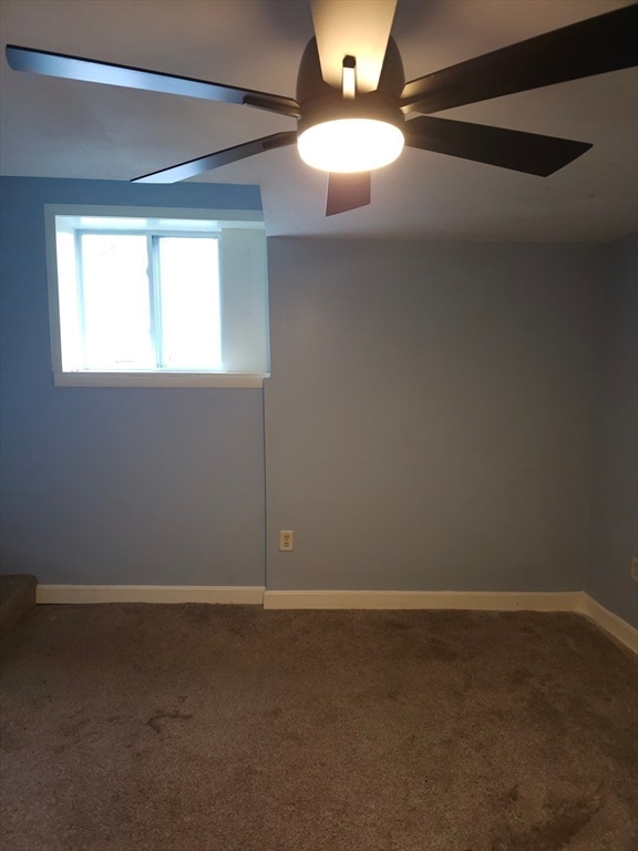 carpeted spare room featuring ceiling fan