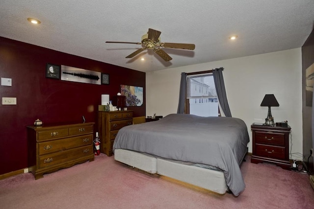 carpeted bedroom with ceiling fan and a textured ceiling