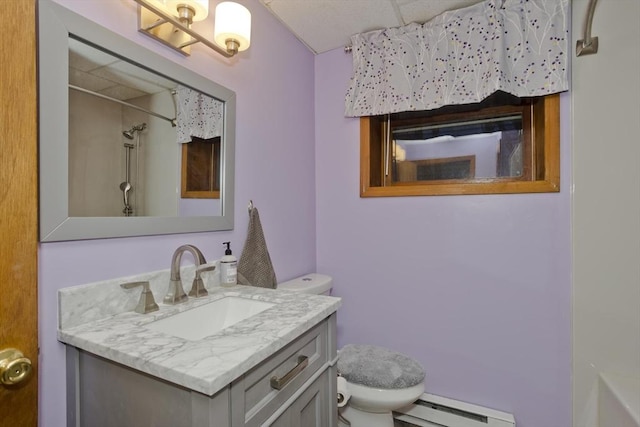 bathroom with vanity, a baseboard heating unit, and toilet