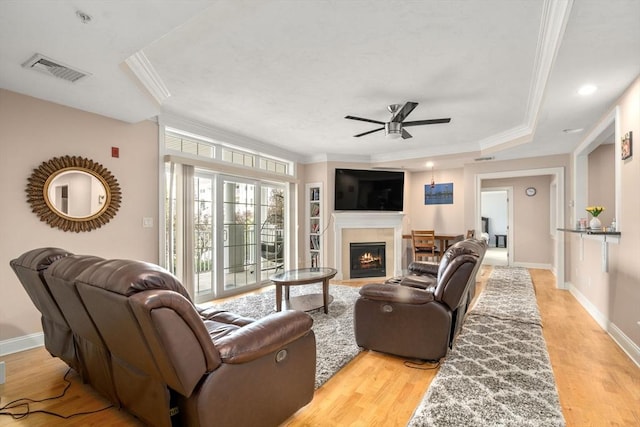 living room featuring light wood-type flooring, ceiling fan, and crown molding