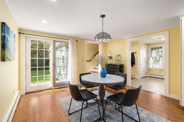 dining room featuring stairs, baseboard heating, and a healthy amount of sunlight