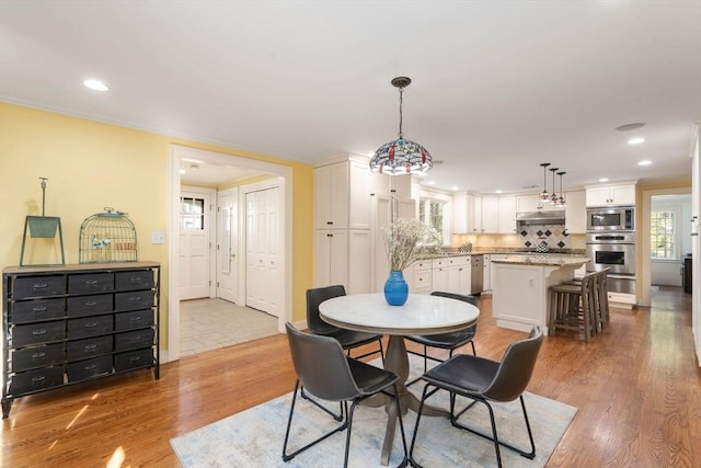 dining space with recessed lighting and light wood-style flooring
