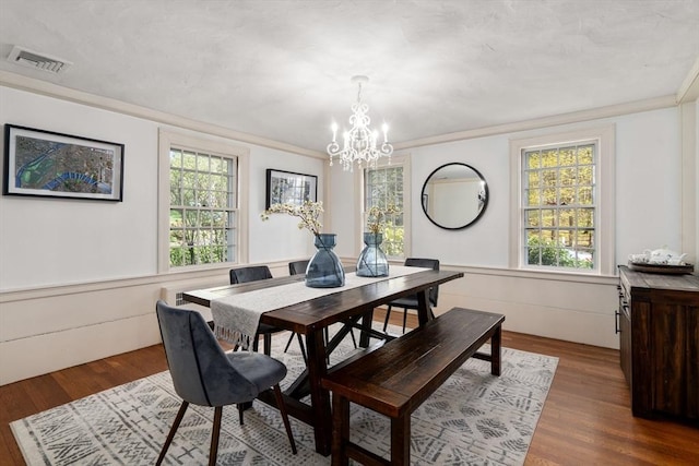 dining space with an inviting chandelier, dark wood-style floors, a healthy amount of sunlight, and visible vents