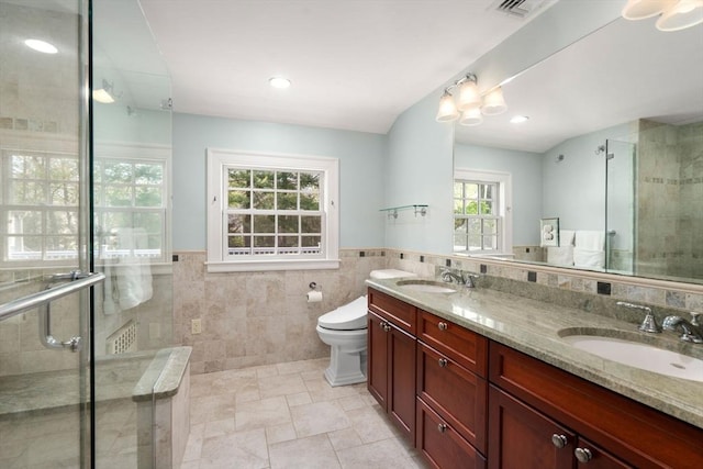 bathroom featuring a sink, a stall shower, and a wealth of natural light