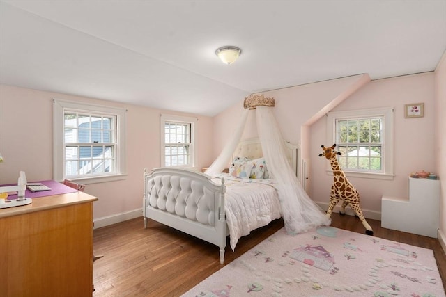 bedroom with light wood-style floors, baseboards, and lofted ceiling