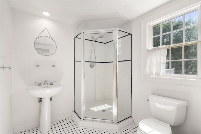 bathroom featuring baseboards, a shower stall, and toilet