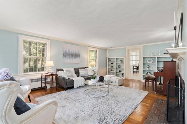 living area with dark wood-type flooring, ornamental molding, and radiator
