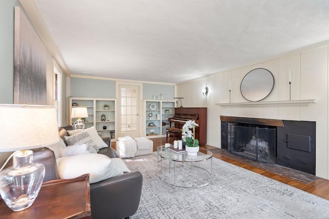 living room featuring ornamental molding, wood finished floors, and a tile fireplace