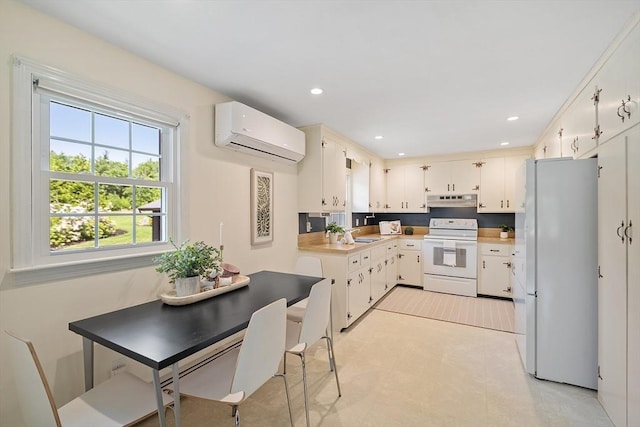 481 W Townsend Rd, Lunenburg, MA 01462 - kitchen featuring white appliances, a wall unit AC, under cabinet range hood, light countertops, and white cabinetry
