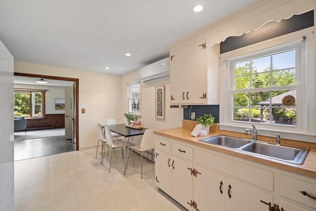 481 W Townsend Rd, Lunenburg, MA 01462 - kitchen with a wall unit AC, light countertops, recessed lighting, decorative backsplash, and white cabinetry