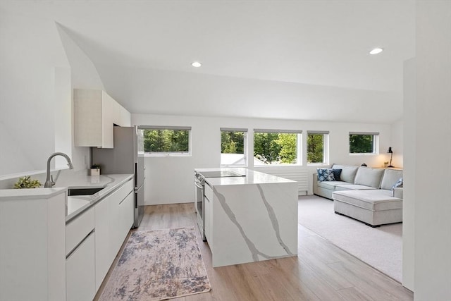 481 W Townsend Rd, Lunenburg, MA 01462 - kitchen with stainless steel electric range, light wood-style floors, white cabinetry, a center island, and recessed lighting