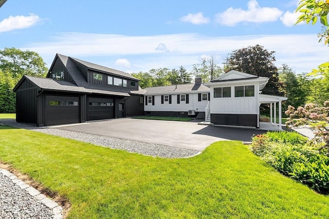 481 W Townsend Rd, Lunenburg, MA 01462 - rear view of property featuring board and batten siding, a garage, a lawn, and asphalt driveway