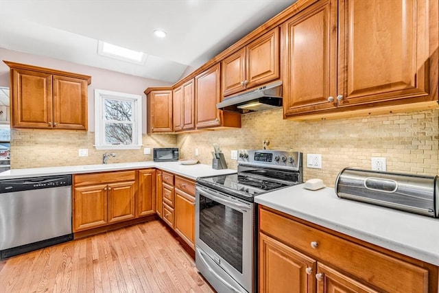 50 Walnut St, Lynn, MA 01905 - kitchen with stainless steel appliances, under cabinet range hood, light wood-style floors, light countertops, and brown cabinetry