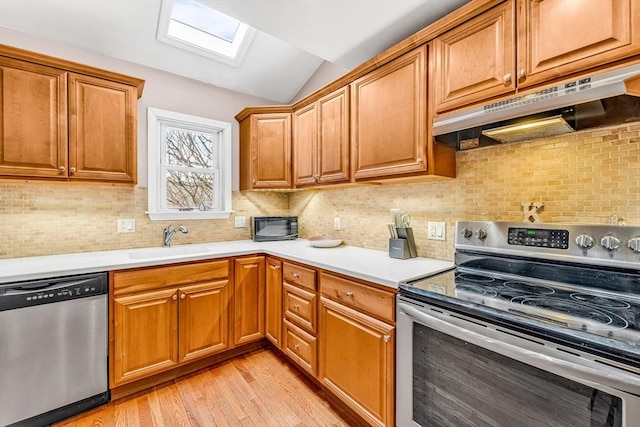 50 Walnut St, Lynn, MA 01905 - kitchen with appliances with stainless steel finishes, under cabinet range hood, lofted ceiling, a sink, and light wood finished floors