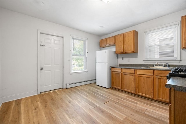 36 Brookford St, Boston, MA 02125 - kitchen with freestanding refrigerator, baseboard heating, dark countertops, light wood finished floors, and brown cabinets