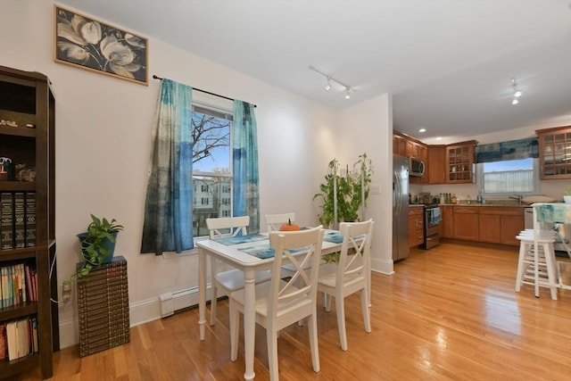 36 Brookford St, Boston, MA 02125 - dining area featuring light wood-type flooring, a baseboard radiator, track lighting, and baseboards