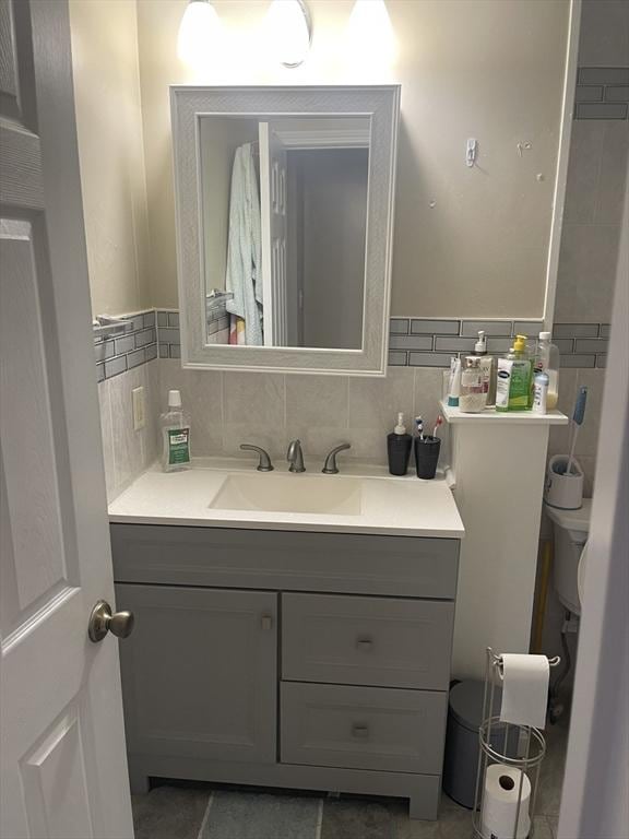 bathroom featuring vanity and backsplash