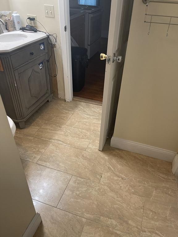 bathroom with vanity, washer / dryer, and baseboards