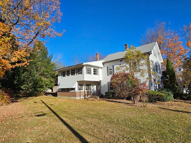 rear view of house featuring a yard