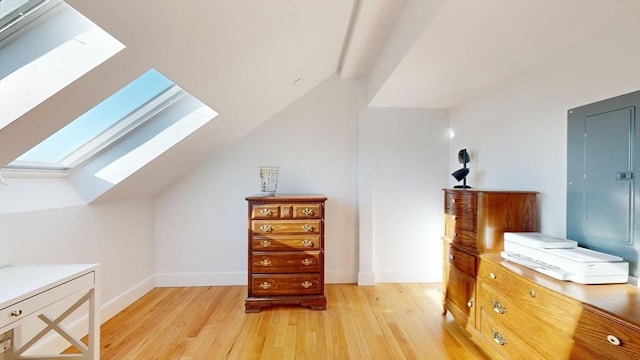 52 Sanborn St Unit 408, Reading, MA 01867 - interior space with electric panel, light wood-style flooring, baseboards, and vaulted ceiling with skylight