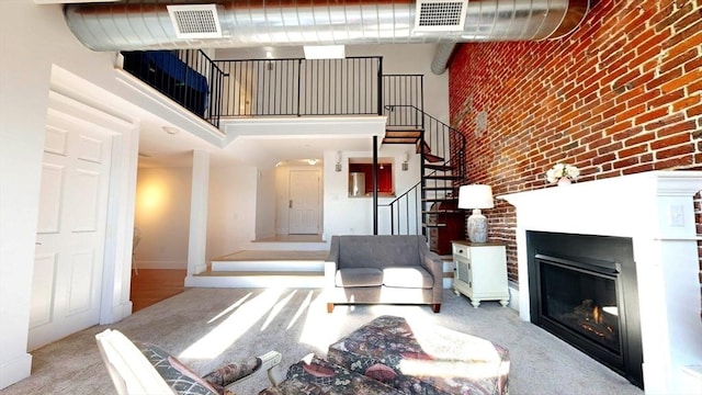 52 Sanborn St Unit 408, Reading, MA 01867 - living area featuring carpet, visible vents, a towering ceiling, and stairs